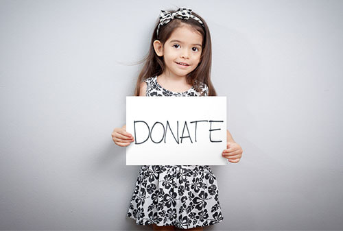 Girl holding up donate sign